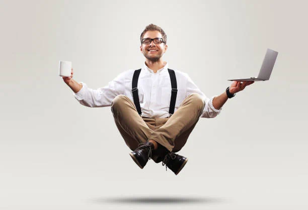 The man is floating a cup of coffee on one side and a laptop on the other